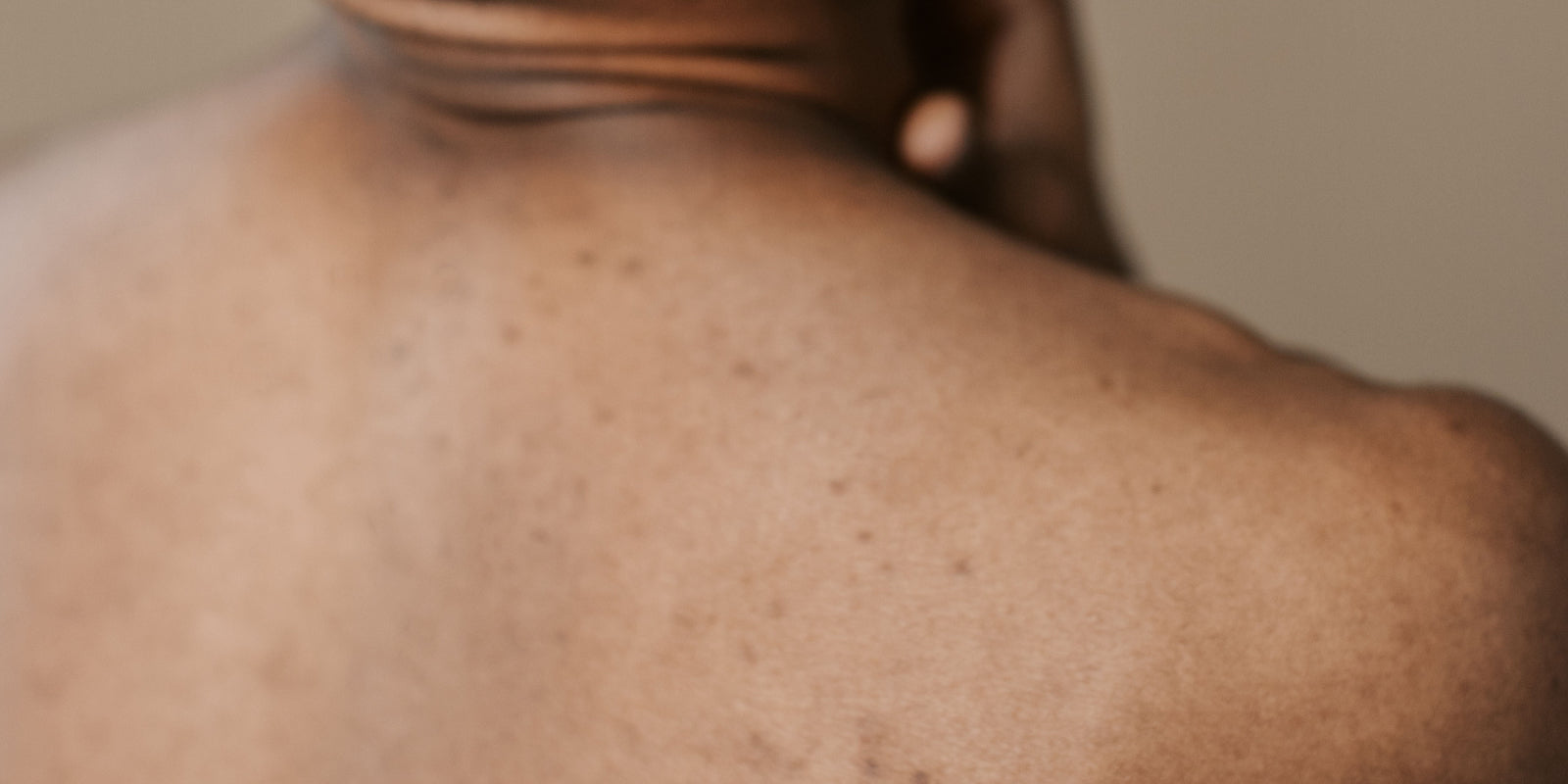 Close-up of a person's back with a neutral background