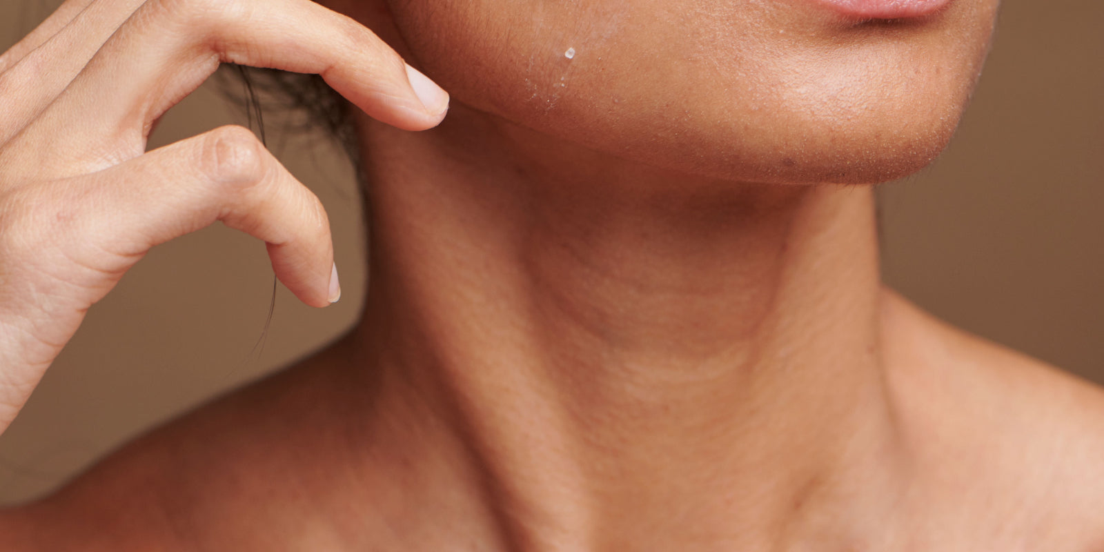 Close-up of a person's neck with a neutral background