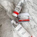 Three skincare products from Enemey on a textured surface